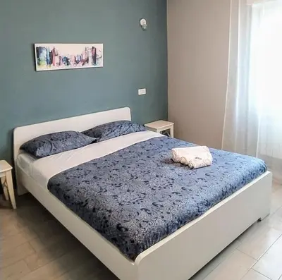 a bedroom with a bed with a blue comforter at Pretty Tiburtina Room in Rome