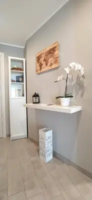 a white counter with a flower in a vase on a wall at Pretty Tiburtina Room in Rome