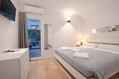 a white bedroom with a large bed and a window at Pied a Terre Barberini in Rome