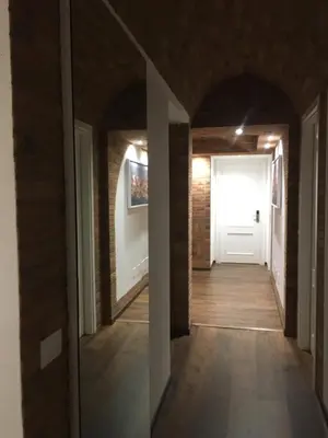 a hallway with a white door and a brick wall at Il Faro Gianicolense in Rome