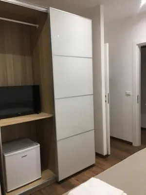 a closet with white drawers and a tv at Il Faro Gianicolense in Rome