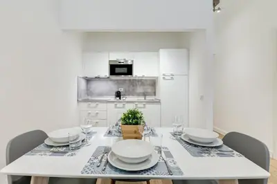 a white dining room with a table and chairs at Germanico Luxury Apartment in Rome