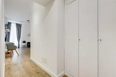 a living room with white walls and a wooden floor at Germanico Luxury Apartment in Rome