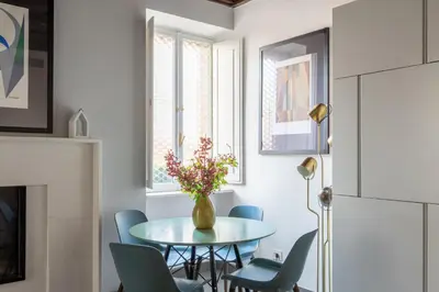 a dining room with a table and chairs and a vase with flowers at Monti Exclusive Medieval Tower in Rome