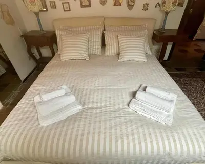 a large bed with white blankets and pillows on it at Penelope's House in Rome