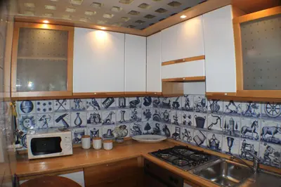 a kitchen with blue and white tile on the wall at Penelope's House in Rome