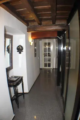 a hallway with a table and a chair and a mirror at Penelope's House in Rome