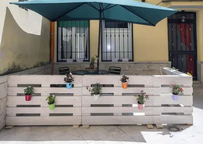 a wooden fence with potted plants and an umbrella at Il Cortiletto di Via Tuscolana in Rome