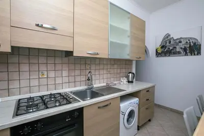 a kitchen with a sink and a washing machine at Il Cortiletto di Via Tuscolana in Rome