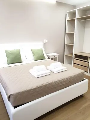 a white bedroom with a large bed with two pillows at T&T Luxury Home Rome int 4 in Rome