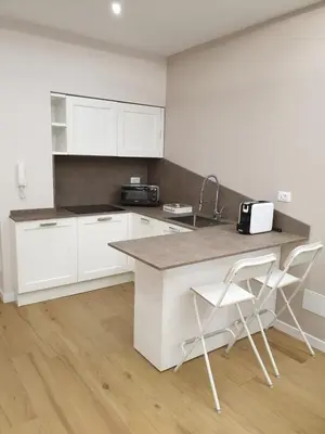 a kitchen with white cabinets and a counter and a chair at T&T Luxury Home Rome int 4 in Rome