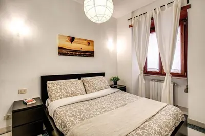 a bedroom with a bed and a large window at Popolo accommodation - Lovely Central apartment in Rome