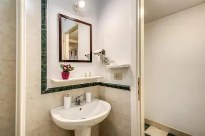 a bathroom with a sink and a mirror at Popolo accommodation - Lovely Central apartment in Rome