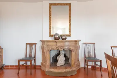 a fireplace in a room with two chairs and a mirror at The Great View in Rome