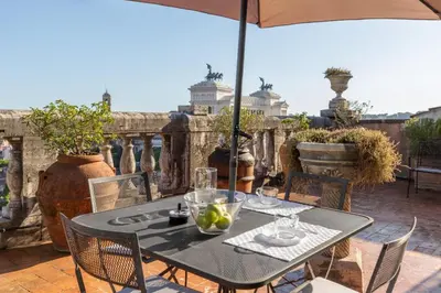 a table and chairs on a patio with an umbrella at The Great View in Rome