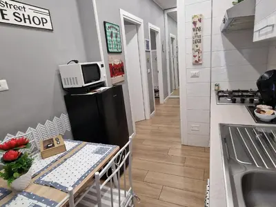 a small kitchen with a table and a refrigerator at Homey in Rome