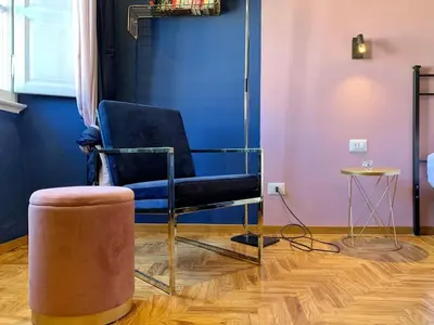 a room with a chair and a stool and a table at GLAM 50 - Exlusive Penthouse in the Heart of Rome in Rome