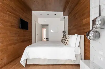 a bedroom with a white bed and wooden walls at Louly Trevi Fountain in Rome