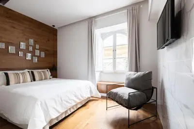 a bedroom with a bed and a chair and a television at Louly Trevi Fountain in Rome