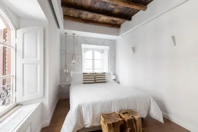 a white bedroom with a bed and a window at Louly Trevi Fountain in Rome
