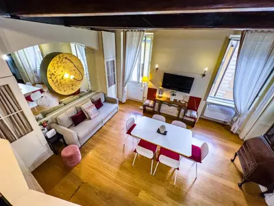a living room with a table and chairs at Piazza Navona Historic 2BR Loft Steps to Square IREX Apartment in Rome