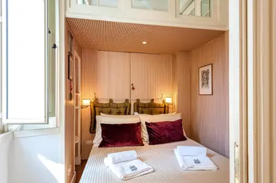a bedroom with a window and a bed with a table at Piazza Navona Historic 2BR Loft Steps to Square IREX Apartment in Rome