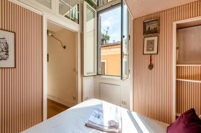a bedroom with a bed with purple and white pillows at Piazza Navona Historic 2BR Loft Steps to Square IREX Apartment in Rome