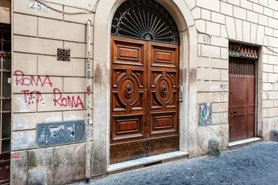 an alley in an old town with a wooden door at Piazza Navona Historic 2BR Loft Steps to Square IREX Apartment in Rome