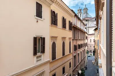 a bedroom with a bed with purple pillows and a window at Piazza Navona Historic 2BR Loft Steps to Square IREX Apartment in Rome