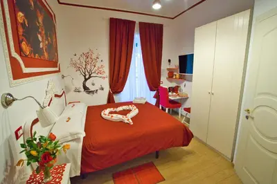 a bedroom with a bed with a red blanket at Etere in Prati Rooms in Rome
