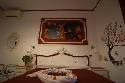 a bedroom with a bed with a painting on the wall at Etere in Prati Rooms in Rome