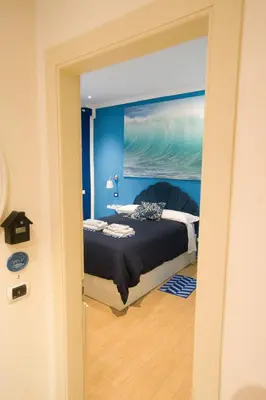 a bedroom with a bed with a blue wall at Etere in Prati Rooms in Rome