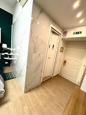 a room with a white marble wall and a door at Etere in Prati Rooms in Rome