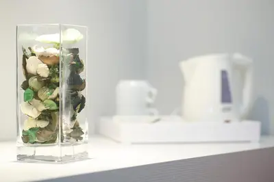 a glass vase filled with vegetables on a counter at NearHome Smart Suites Guest House in Rome