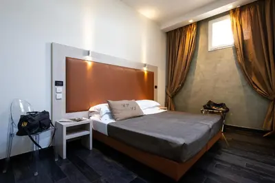 a bedroom with a bed with a large headboard at Borgo Pio Suites Inn in Rome