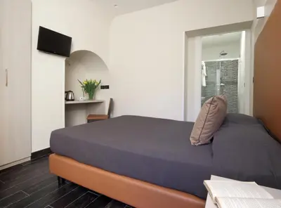 a bedroom with a bed with a blue comforter at Borgo Pio Suites Inn in Rome