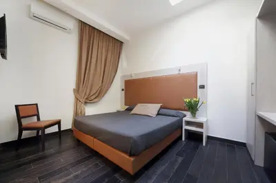 a bedroom with a bed and a chair at Borgo Pio Suites Inn in Rome