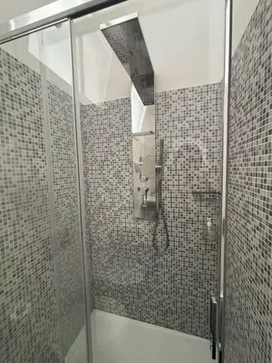 a bathroom with a shower with a glass door at Borgo Pio Suites Inn in Rome