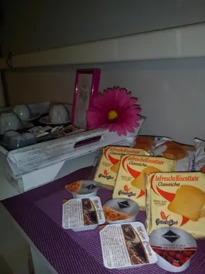 a table with some food and a flower on it at Vatican Rooms Accommodation in Rome