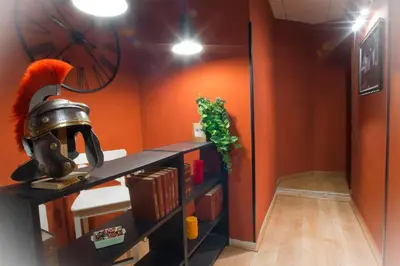 a room with orange walls and a table with a helmet at Vatican Rooms Accommodation in Rome