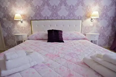 a bedroom with a pink bed with a purple pillow at Vatican Rooms Accommodation in Rome