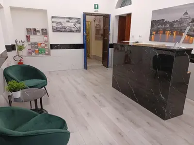 a room with two green chairs and a counter at Hotel Mimosa Pantheon in Rome