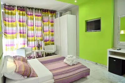 a room with green walls and a bed with a teddy bear at G&G Trastevere in Rome