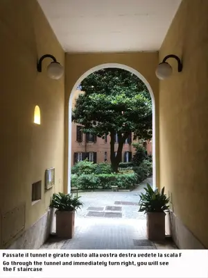 an archway in a building with a tree and a courtyard at B&B Da Ponticello in Rome