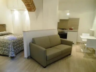 a living room with a couch and a kitchen at Vatican Studio Apartment in Rome