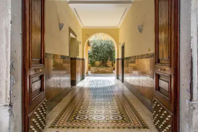 an ornate hallway with a tile floor and wooden doors at Vatican Studio Apartment in Rome