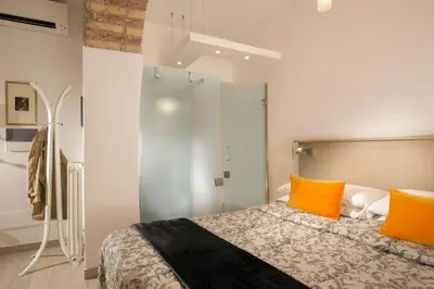 a bedroom with a bed with orange pillows at Vatican Studio Apartment in Rome