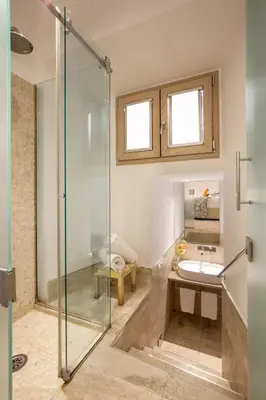 a bathroom with a glass shower and a sink at Vatican Studio Apartment in Rome