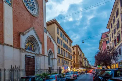 a building with a clock on the side of a street at Vatican Studio Apartment in Rome