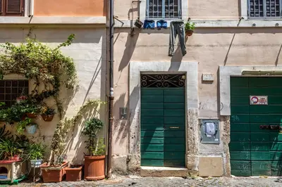 a building with a green door and two plants at iFlat Trastevere Bianca's House in Rome